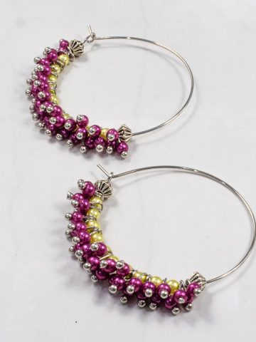 A pair of seed bead earrings in purple and green