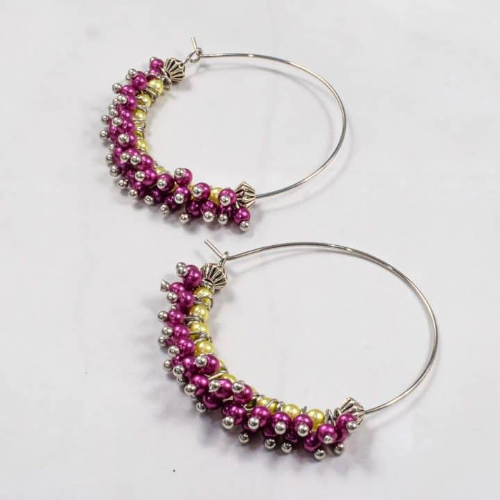 A pair of seed bead earrings in purple and green