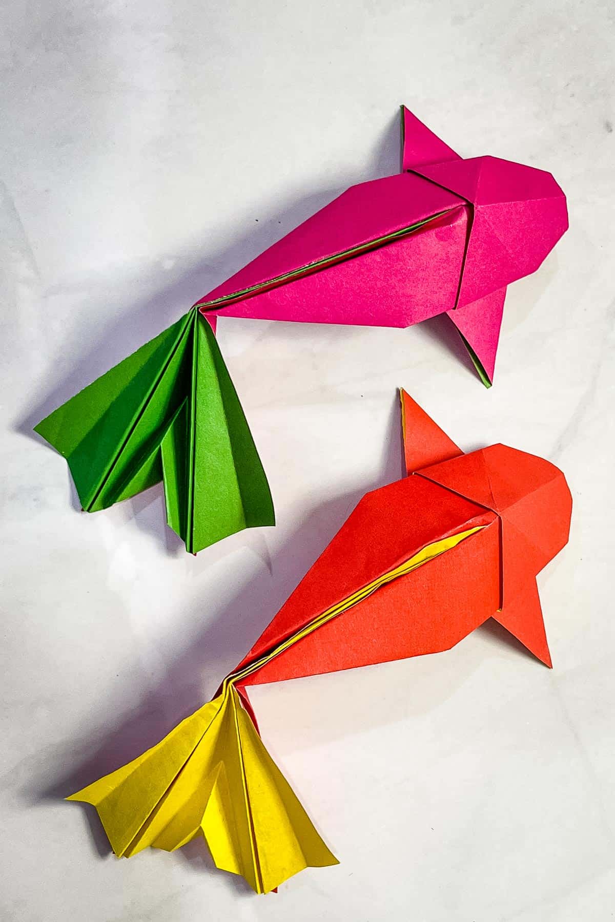 Paper fish in pink, green, red and yellow.