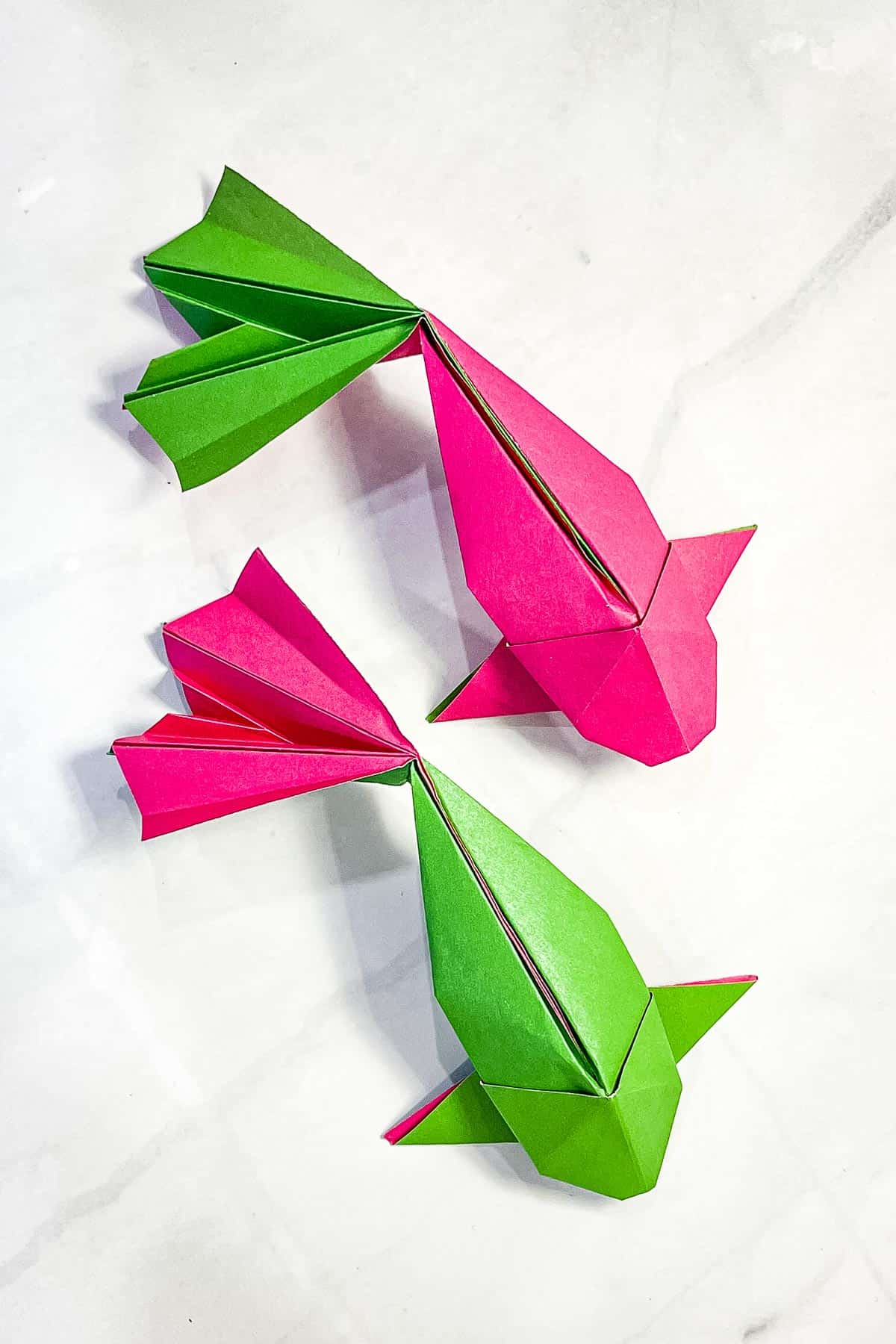 2 origami koi fish in pink and green.