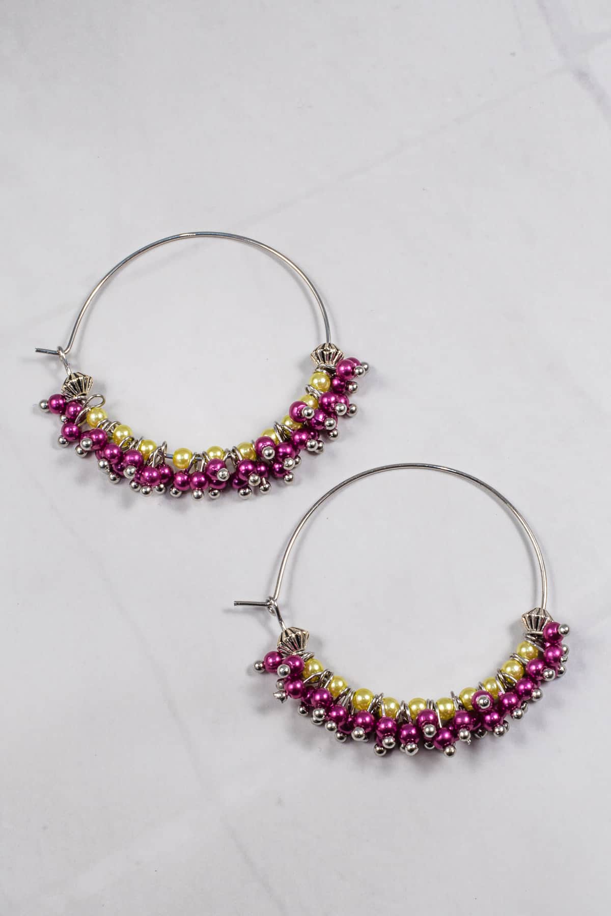 A pair of seed bead earrings in purple and green.