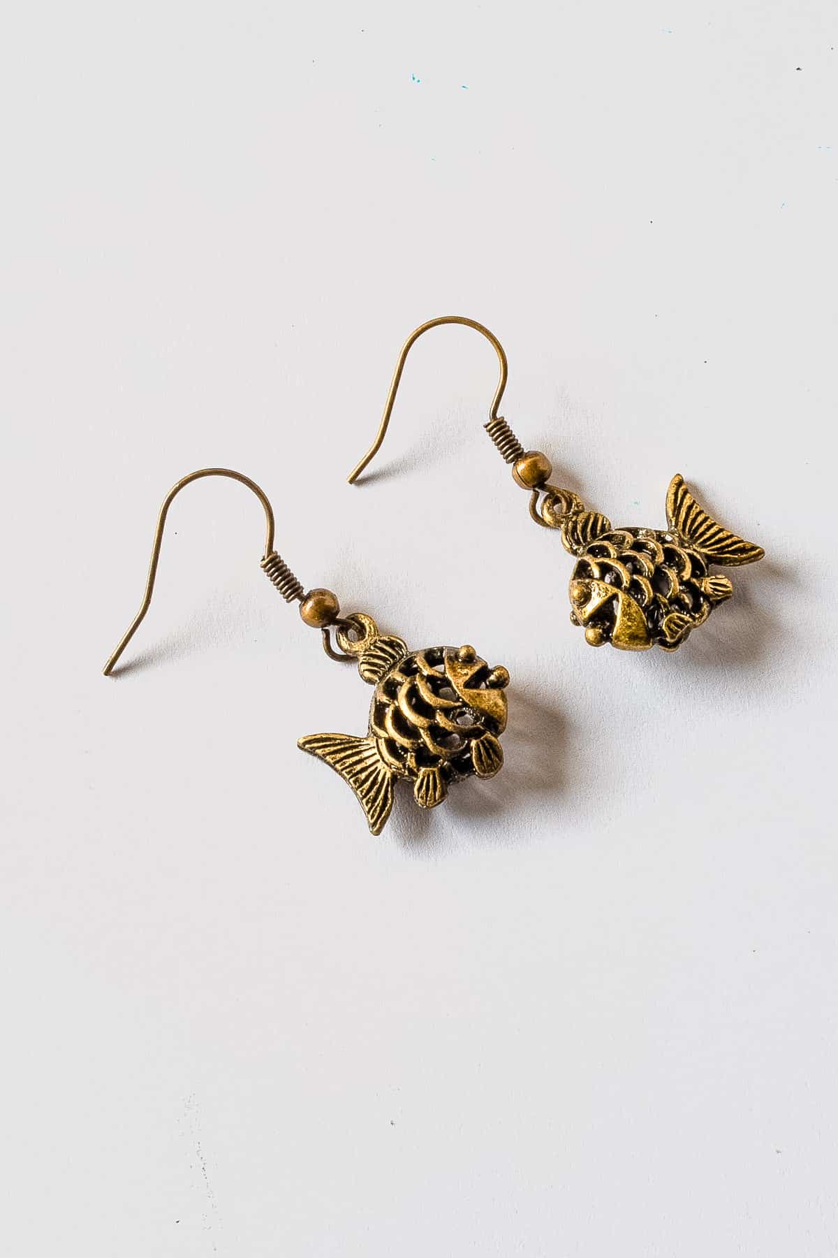 A pair of fish earrings with charms.