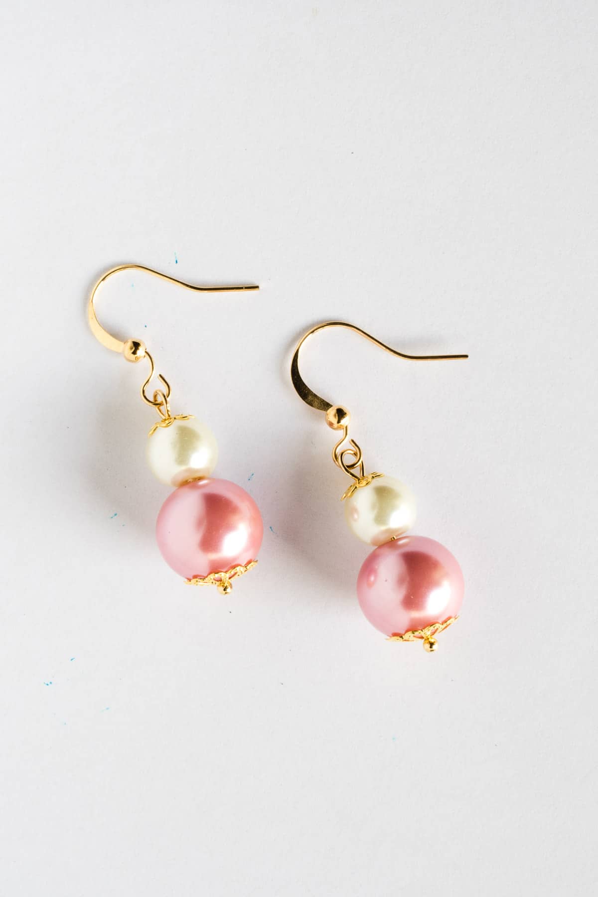 A pair of white and pink earrings.