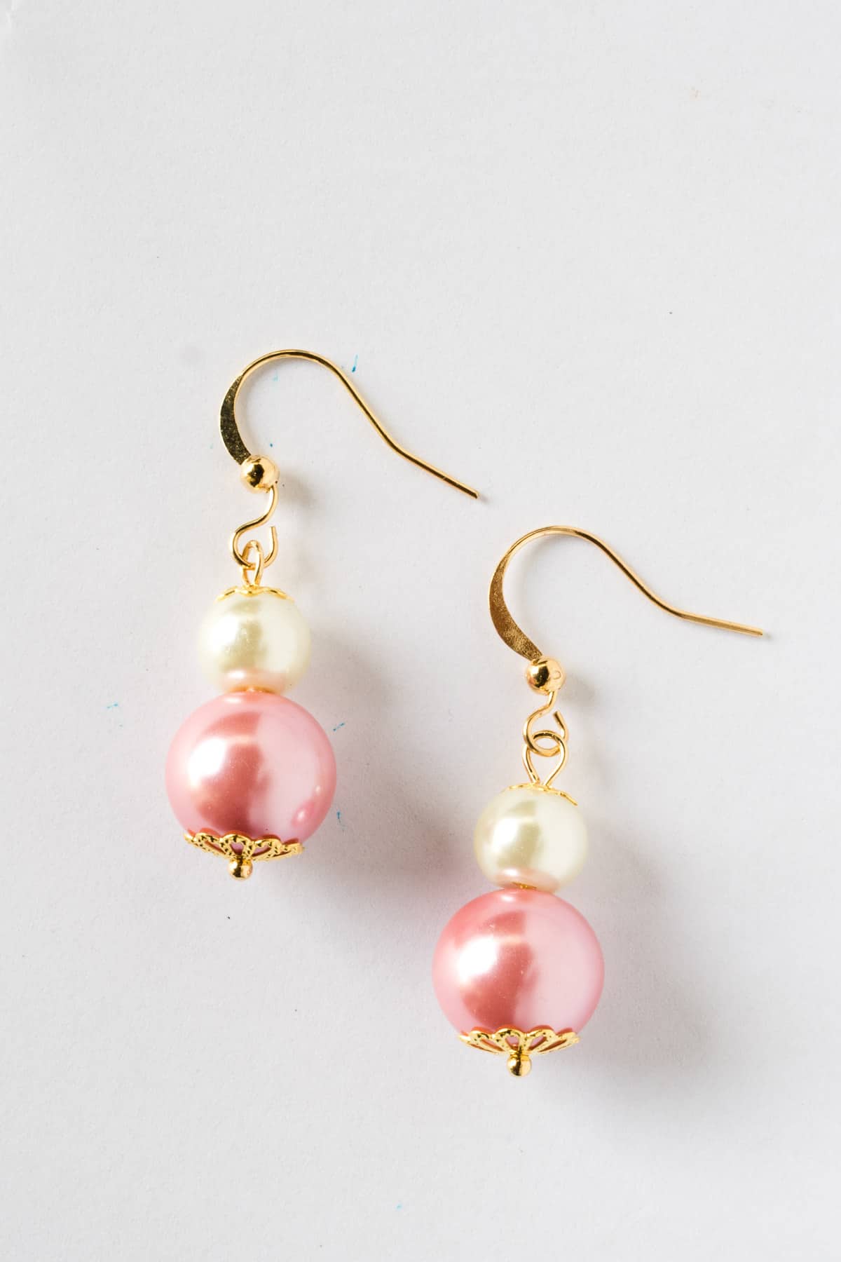 Earring making for beginners - A pair of white and pink earrings.
