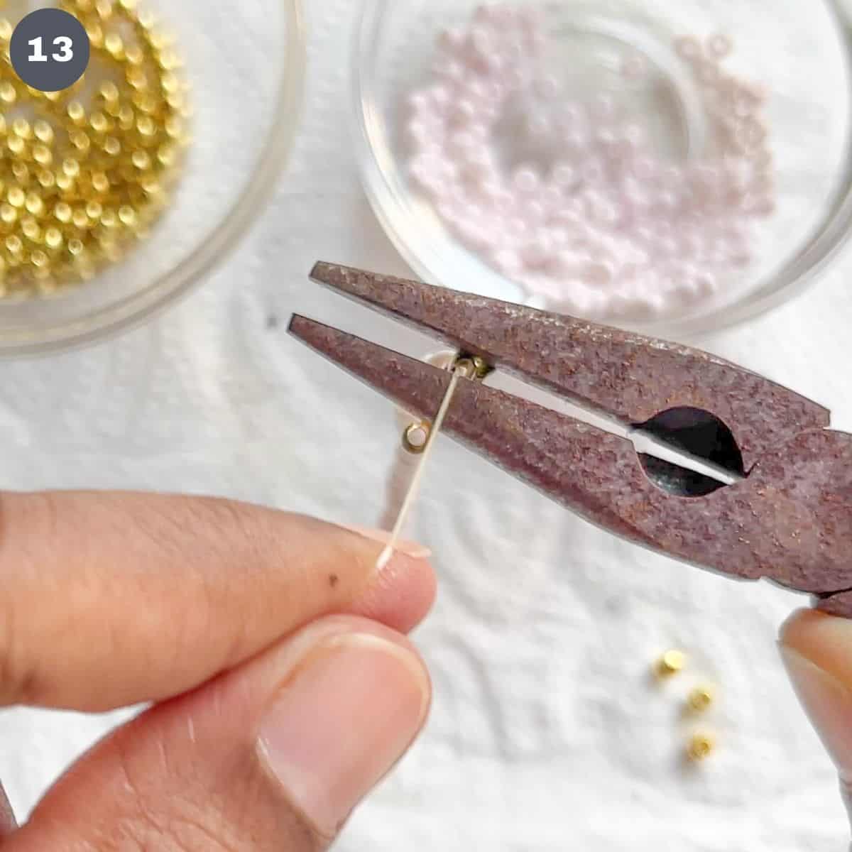 Using a plier to press a crimp bead.