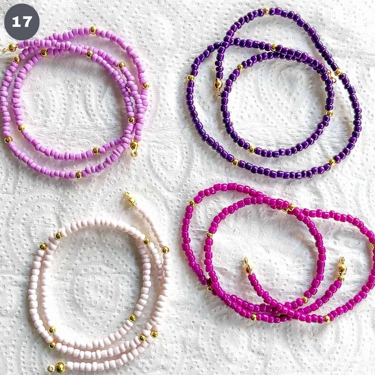 4 strands of beads in different purple hues.