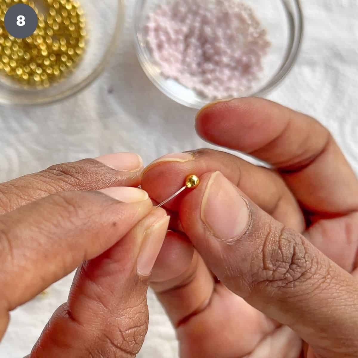 Inserting wire into gold bead.