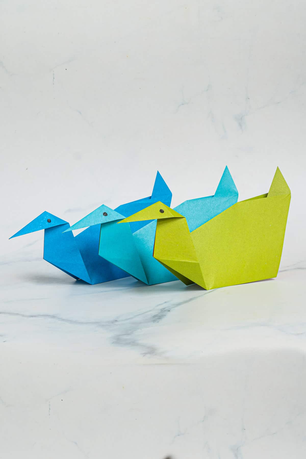 Blue, green and turquoise paper ducks.