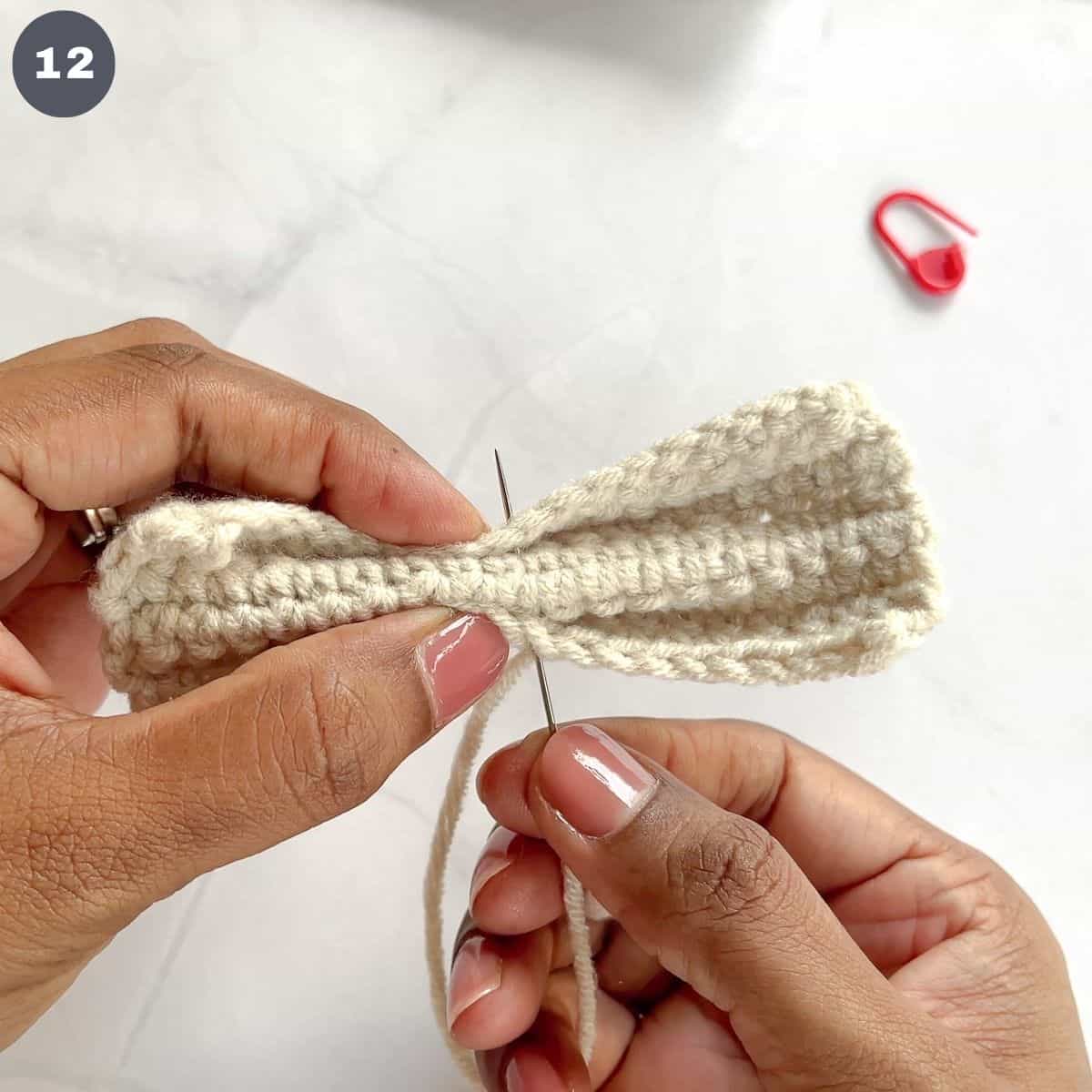 Stitching a crochet bow.