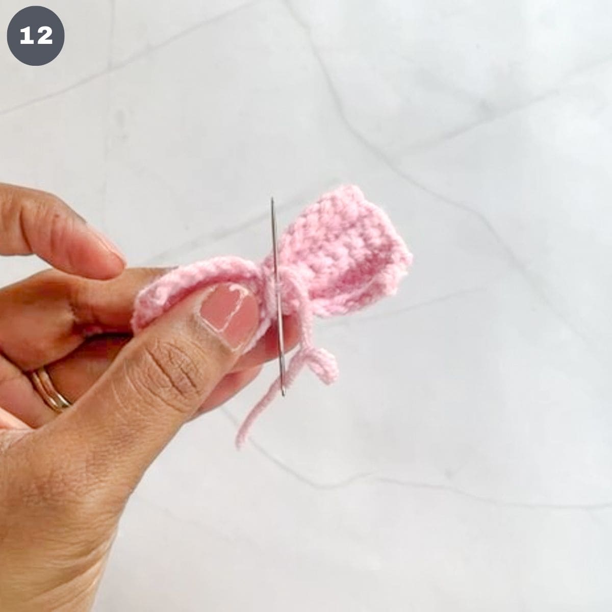 Stitching a crochet bow with a tapestry needle.