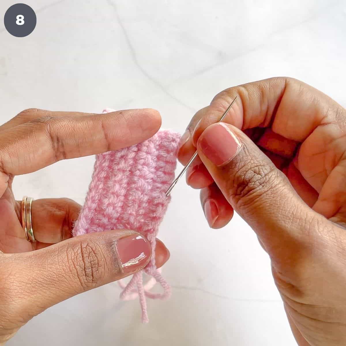 Stitching yarn with a tapestry needle.
