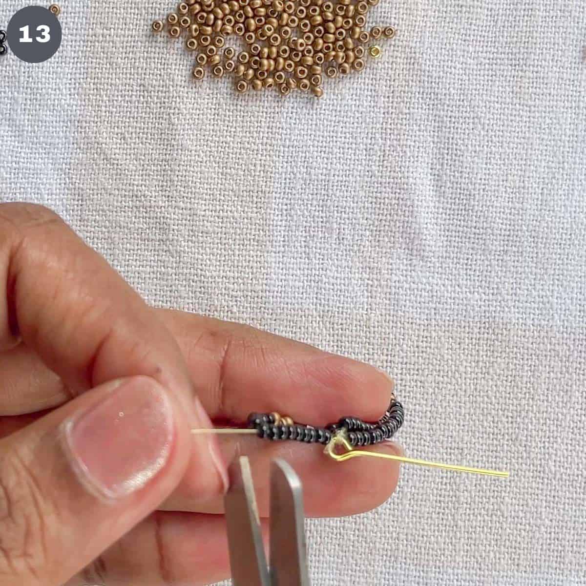 Cutting thread with scissors.