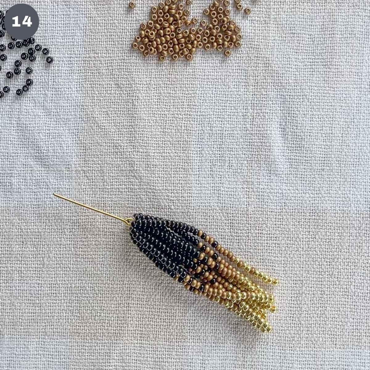 A tassel of black, gold and bronze beads attached to an eye pin.