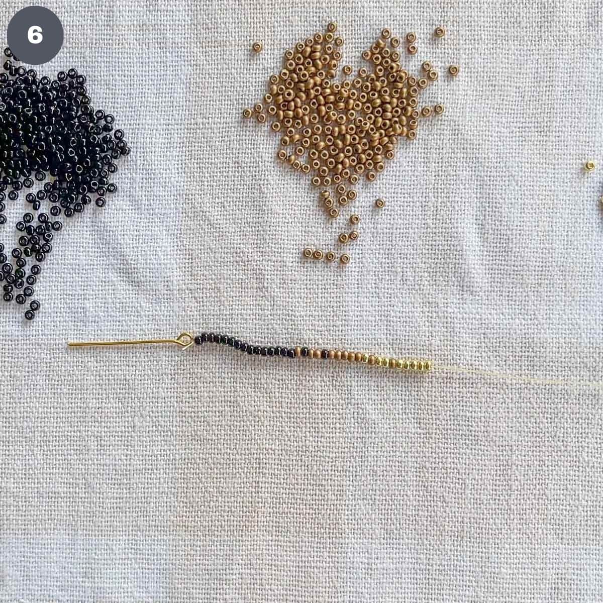 A strand of black, bronze and gold seed beads.