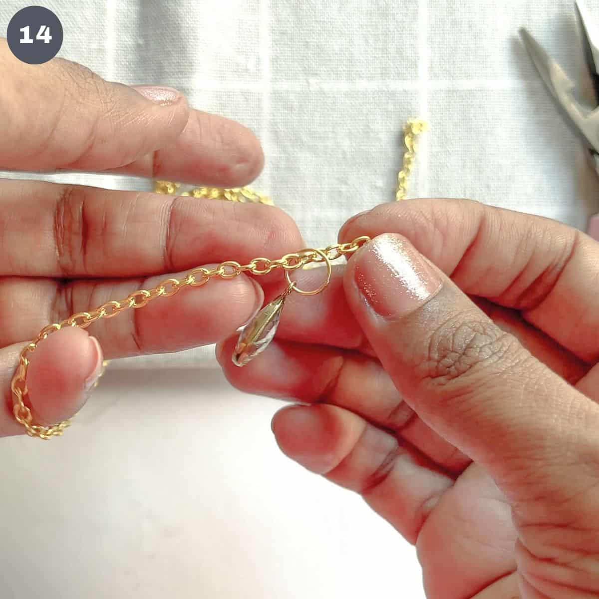 Inserting a pendant into a gold link chain.