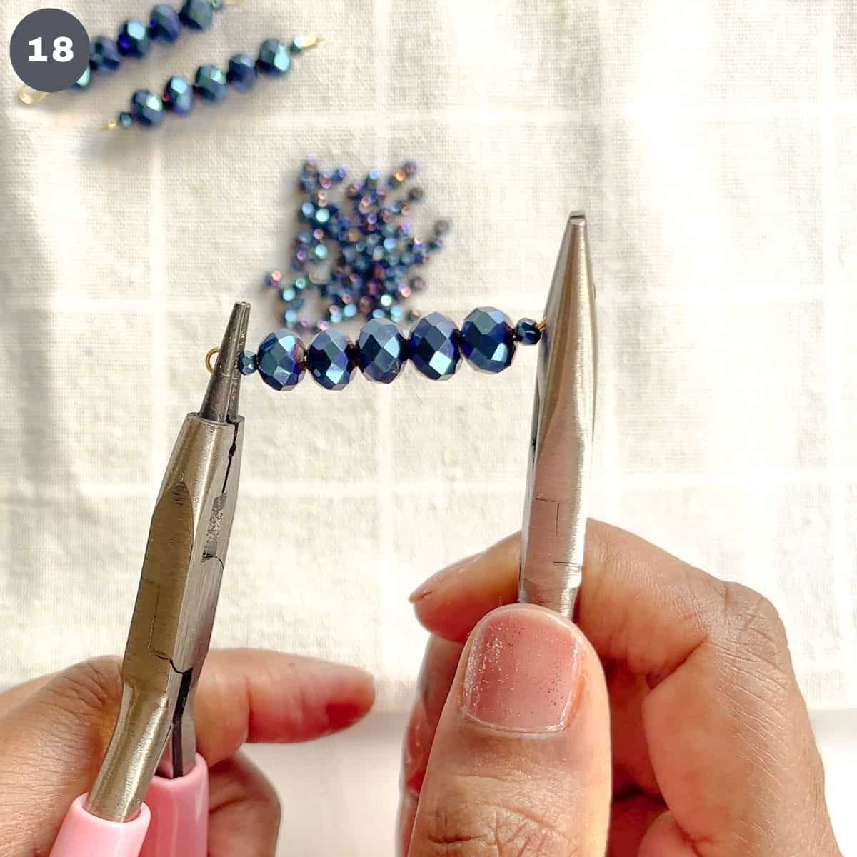 Using pliers to align the hoops on a 7 bead strand.