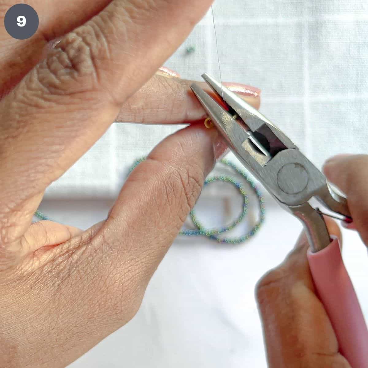 Crimping a bead with pliers.
